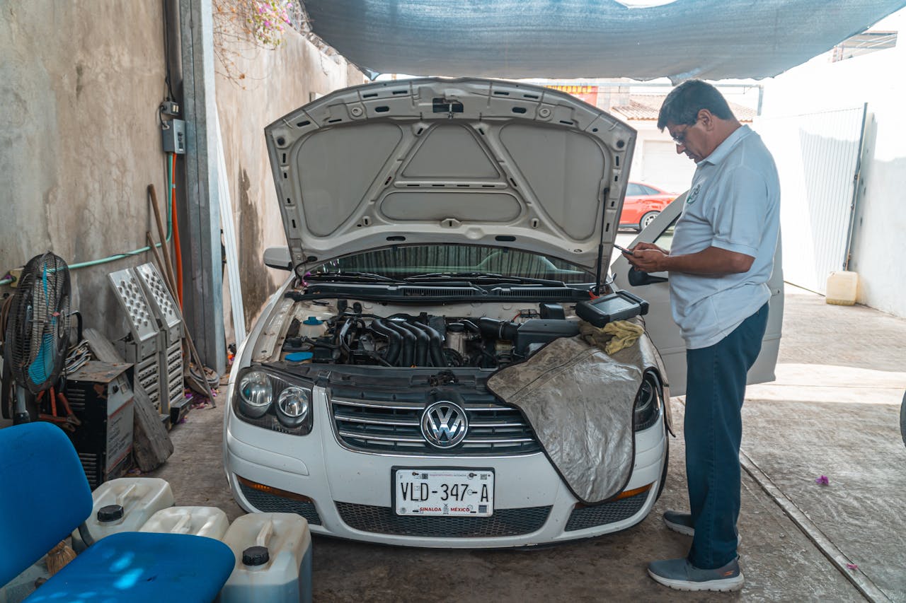 our-story A mechanic examines a Volkswagen engine in a garage setting, focusing on car maintenance.