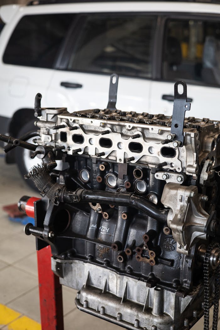 Crafting Captivating Headlines: Your awesome post title goes here Detailed view of a car engine in an auto repair shop with a blurred vehicle in the background.
